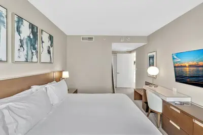 a bedroom with a white bed and a desk and a bed sidx sidx sidx sidx at King Suite balcony water views-Hosted by Sweetstay in Miami Beach