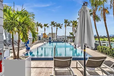 a pool with two chairs and an umbrella at King Suite balcony water views-Hosted by Sweetstay in Miami Beach