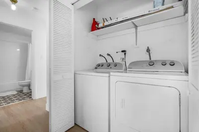 a white kitchen with a washing machine and a sink at Modern 3 Bedroom GetAway with Parking in Coral Gables in Miami