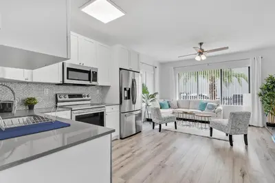 a kitchen with white cabinets and a living room at Wonderful 6ppl Apt 5 min walking Design District 2 in Miami