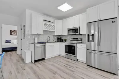 a kitchen with white cabinets and stainless steel appliances at Wonderful 6ppl Apt 5 min walking Design District 2 in Miami