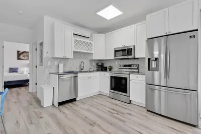 a kitchen with white cabinets and stainless steel appliances at Wonderful 6ppl Apt 5 min walking Design District 2 in Miami