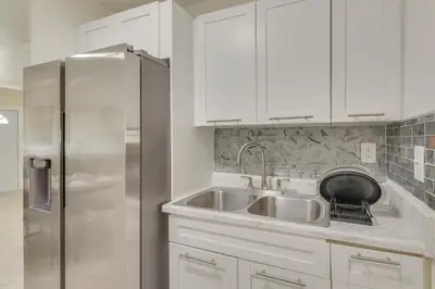 a kitchen with a sink and a stainless steel refrigerator at Miami Gardens Apt 5 Miles to Hard Rock Stadium in Miami Gardens