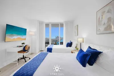a hotel room with a bed and a desk and a bed at Beautiful Studio Amazing View Balcony in Hallandale Beach