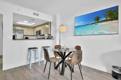 a dining room with a table and chairs and a kitchen at Serene Cozy Retreat with Balcony Free Parking in Miami