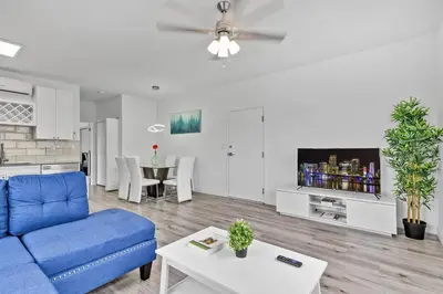 a living room with a blue couch and a table at Magical bright Apt 5min walking Design District apt 5 in Miami