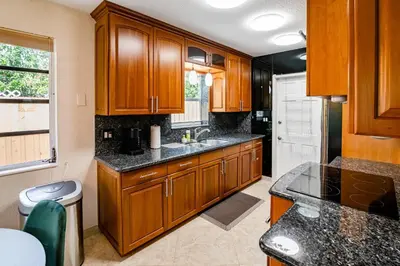 a kitchen with wooden cabinets and a sink at Charming 2BR Waterfront House in Fort Lauderdale