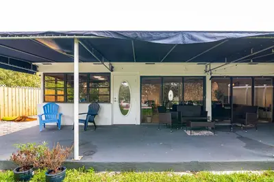 a screened in porch with chairs and a table at Charming 2BR Waterfront House in Fort Lauderdale