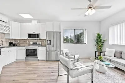 a kitchen with white cabinets and a living room at Quiet Bright Apt 5min walking to Design District apt 6 in Miami