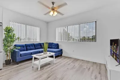 a living room with a blue couch and a table at Stylish Lux Apt 5 min walking to Design District apt 7 in Miami