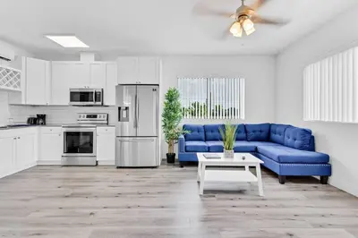 a living room with a blue couch and a kitchen at Stylish Lux Apt 5 min walking to Design District apt 7 in Miami
