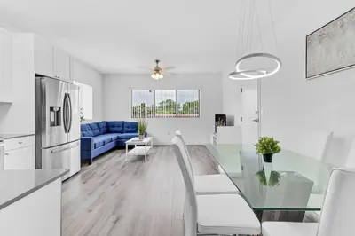 a white kitchen and living room with a glass table at Stylish Lux Apt 5 min walking to Design District apt 7 in Miami