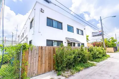 a white house with a fence in front of it at Comfy Apt 5 min walking to Design District apt 4 in Miami
