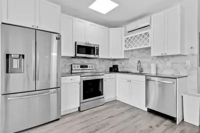 a kitchen with white cabinets and stainless steel appliances at Comfy Apt 5 min walking to Design District apt 4 in Miami