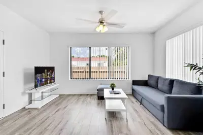 a living room with a blue couch and a tv at Comfy Apt 5 min walking to Design District apt 4 in Miami