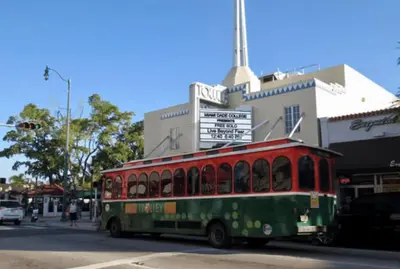 a red and green bus driving down a street at Coco Sol 2 by MyMiamiStay in Miami
