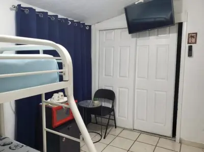 a room with a bunk bed with a tv and a door at Coco Sol 2 by MyMiamiStay in Miami
