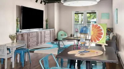 a living room with tables and chairs and a flat screen tv at Marriott Villas at Doral 2BD sleeps 8 in Miami