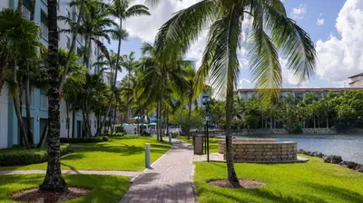 a walkway with palm trees in front of a building at Marriott Villas at Doral 2BD sleeps 8 in Miami