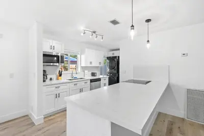 a white kitchen with a large white counter top at Weekly Discounts 10 min to Beach by TilahStays in Fort Lauderdale
