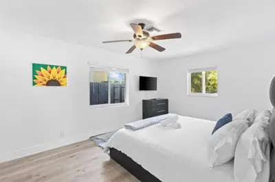 a white bedroom with a bed and a ceiling fan at Weekly Discounts 10 min to Beach by TilahStays in Fort Lauderdale