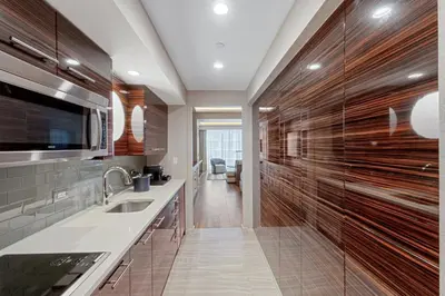 a kitchen with wooden cabinets and a sink at Stylish Oceanview Apartment Prime Location in Fort Lauderdale