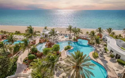 an aerial view of a resort with a swimming pool and the beach at Ocean View Luxurious Studio Premium Amenities in Sunny Isles Beach
