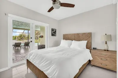 a white bedroom with a bed and a patio at Waterfront Pool & Amazing Location - WOW in Miami