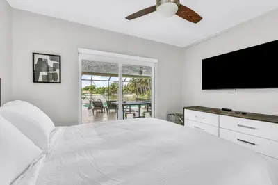 a white bedroom with a bed and a flat screen tv at Waterfront Pool & Amazing Location - WOW in Miami