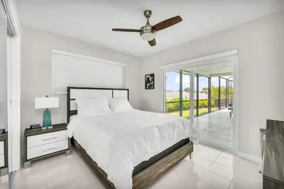 a white bedroom with a bed and a large window at Waterfront Pool & Amazing Location - WOW in Miami