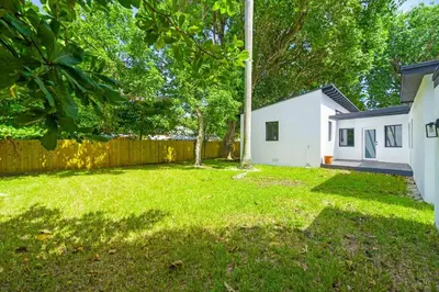 a yard with a fence and a house at Spacious Retreat with Green Areas 8 ppl in Miami