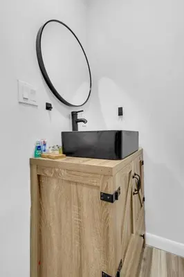 a bathroom sink with a mirror on top of a wooden cabinet at Spacious Retreat with Green Areas 8 ppl in Miami