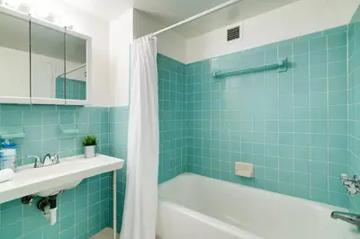 a bathroom with a tub and a sink and blue tile at 1101- Luxurious 1BR & 2 Bath with City & Ocean Views in Miami Beach