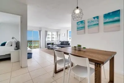 a dining room and living room with a table and chairs at 1101- Luxurious 1BR & 2 Bath with City & Ocean Views in Miami Beach