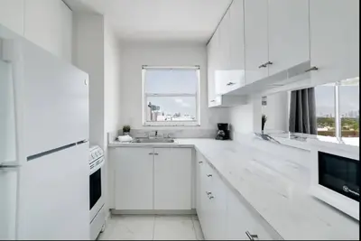 a white kitchen with a sink and a window at 1106- 1BR & 1BA with Balcony, Stunning City & Ocean Views in Miami Beach