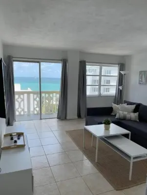 a living room with a blue couch and a table at 1401- Stylish 1BR& 2BA with Breathtaking Ocean Views in Miami Beach