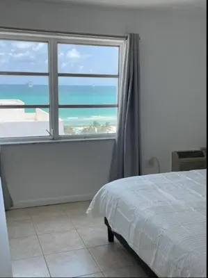 a bedroom with a large window with a view of the ocean at 1401- Stylish 1BR& 2BA with Breathtaking Ocean Views in Miami Beach