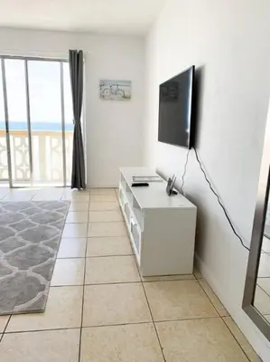 a living room with a flat screen tv on a wall at 1402- Oceanfront 1BR & 1 Bath Retreat with Stunning Views in Miami Beach