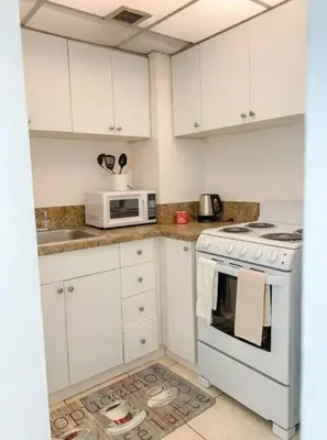 a white kitchen with a stove and a microwave at 1402- Oceanfront 1BR & 1 Bath Retreat with Stunning Views in Miami Beach