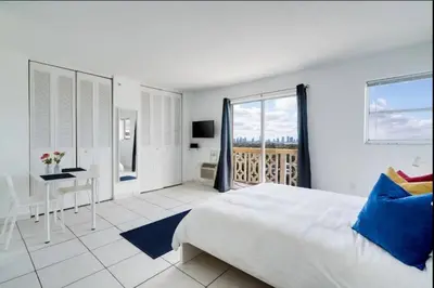 a white bedroom with a large bed and a desk at 1405- South Beach 1BR & 1BA- Stunning Ocean View Oasis in Miami Beach