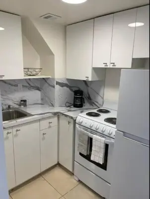 a kitchen with white cabinets and a stove top oven at 1502- Seaside Serenity- 1BR & 1BA, Ocean Views in Miami Beach