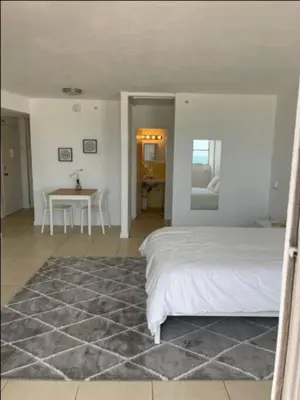a white bedroom with a bed and a table at 1502- Seaside Serenity- 1BR & 1BA, Ocean Views in Miami Beach