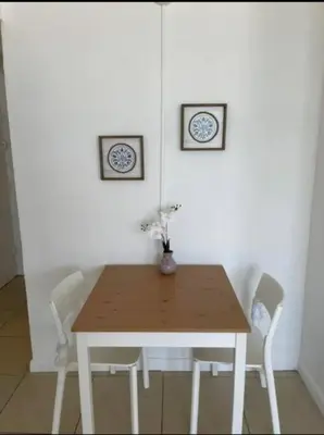 a wooden table with two chairs and two clocks on the wall at 1502- Seaside Serenity- 1BR & 1BA, Ocean Views in Miami Beach
