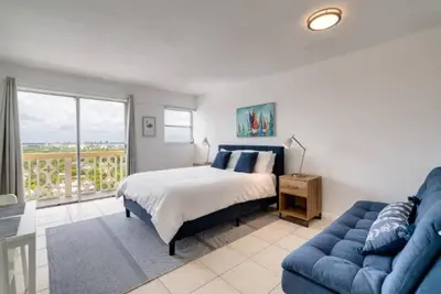 a bedroom with a bed and a blue couch at 1505- Downtown Miami Bay View Retreat with 1BR & 1BA in Miami Beach