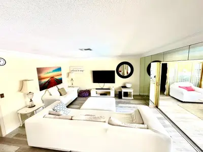 a living room with a white couch and a tv at Fort Lauderdale Beach Oasis in Fort Lauderdale