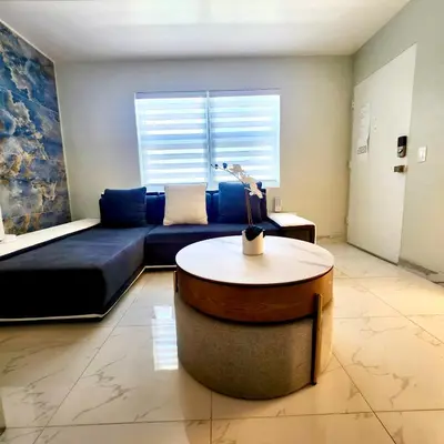 a living room with a blue couch and a table at Luxurious Waterfront 2 room apartment- Remodeled- Free parking- 5min drive to Miami Beach in Miami Beach