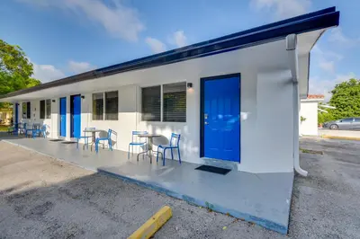 a small white building with chairs and a table at 2 Mi to Ocean Dog-Friendly Hallandale Beach Condo in Hallandale Beach