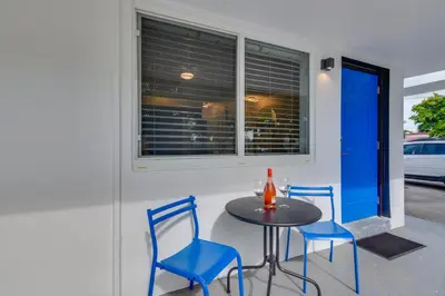 a table and two blue chairs and a window at 2 Mi to Ocean Dog-Friendly Hallandale Beach Condo in Hallandale Beach