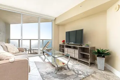 a living room with a couch and a flat screen tv at Beach Vibes & 30th Floor Ocean Views in Sunny Isles Beach
