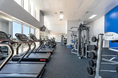 a gym with a row of treadmills and machines at Beach Vibes & 30th Floor Ocean Views in Sunny Isles Beach